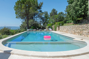 Sun loungers by the pool of Villa La Cauquière overlooking the Luberon valley in Provence.