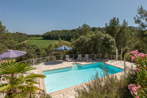 Heated private swimming pool at La Bergerie Caseneuve in Cotignac with sun loungers and surrounding nature.