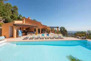 Infinity pool with sun loungers and dining terrace at Villa Lou Bea in Cabris, overlooking the hills of the Côte d’Azur.