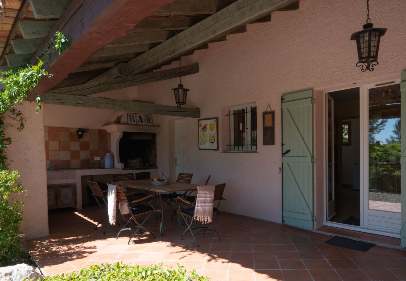 Terrasse im Mas de Charles, mit einem überdachten Bereich mit eingebautem Grill und Esstisch, nahtlos verbunden mit der Küche
