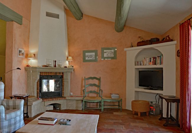84LUCK, Gemütliches Wohnzimmer mit Sitzecke am Kamin und Terrassentüren, Murs, Provence, Südfrankreich
