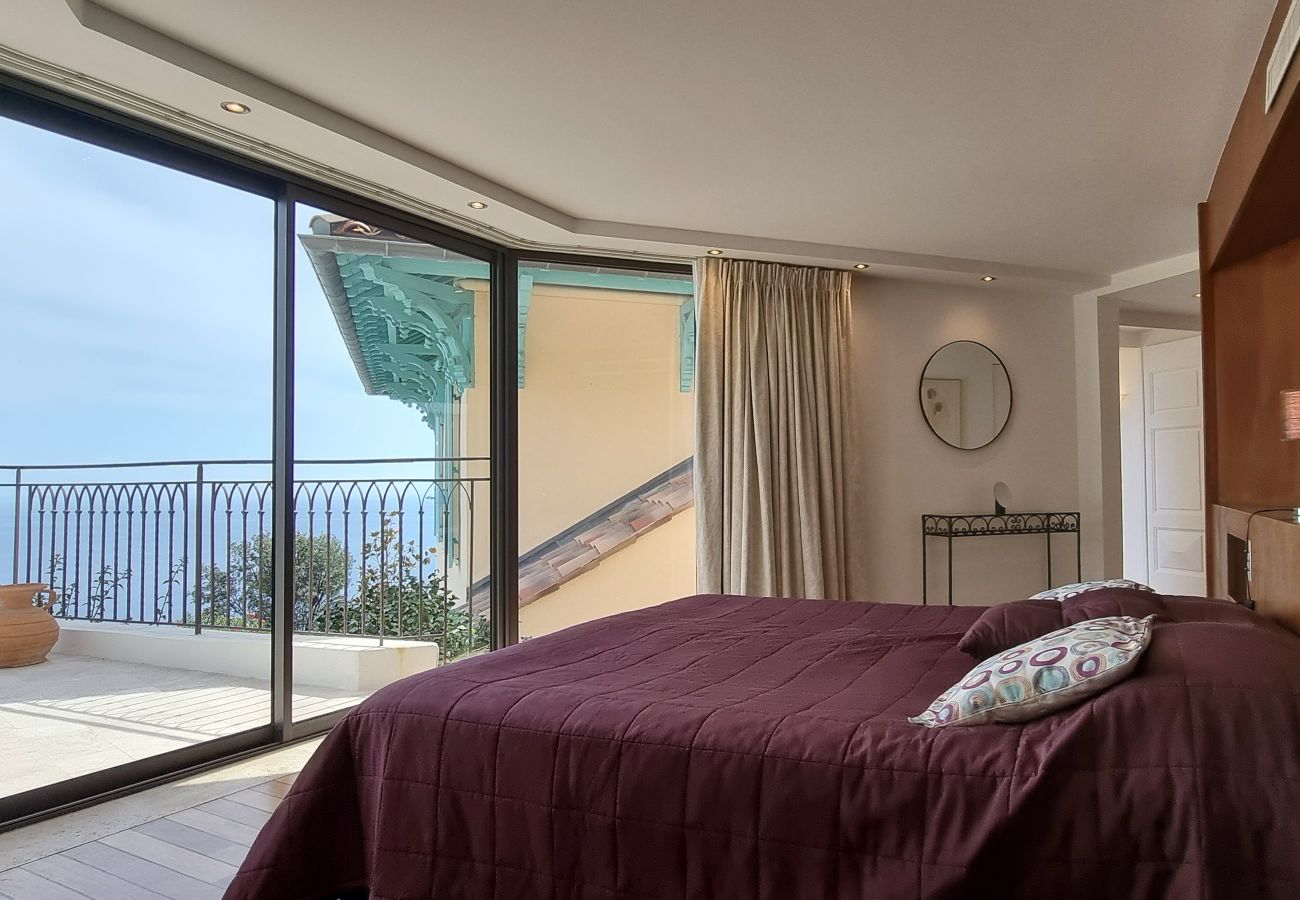 Erleben Sie die Anziehungskraft des Schlafzimmers der Villa 06LERI mit Balkon und atemberaubendem Meerblick