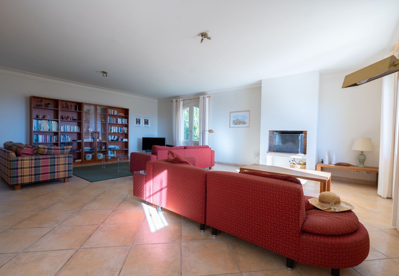 Weitläufige Wohnzimmer der Villa 06PRAD mit Kamin, Terrassentüren und zwei Sitzbereichen