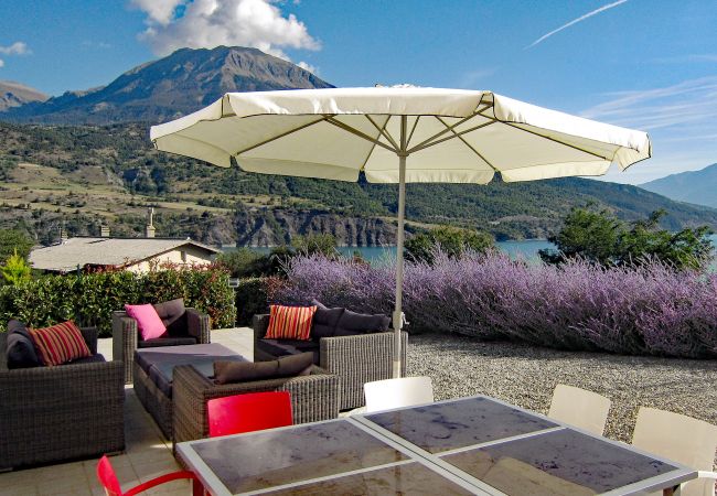 Entspannen Sie in Stil in der Villa Dalaromeri mit Garten, bequemen Möbeln, Sonnenschirm und herrlichem Seeblick