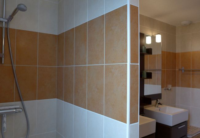 Erleben Sie das gepflegte Badezimmer der Villa Dalaromeri mit Dusche und Doppelwaschbecken