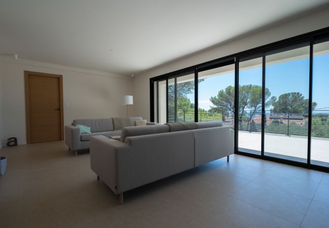 Villa Le 41 - Bild vom geräumigen Wohnzimmer mit Sitzecke an der Glaswand mit Meerblick, Yogaecke, zweiter Sitzbereich 