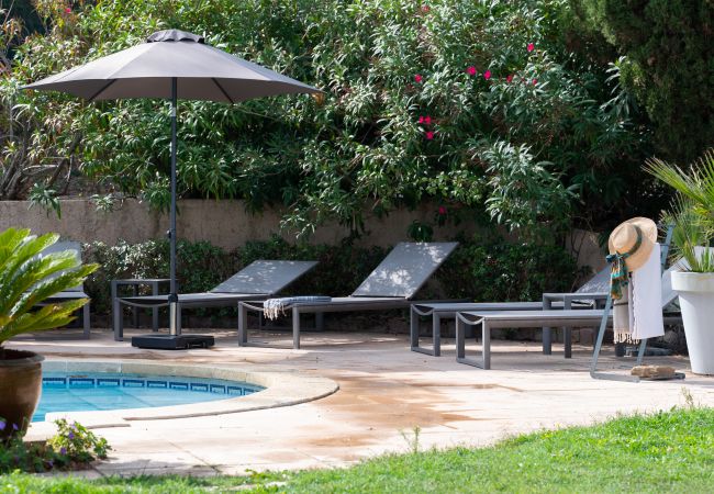 Swimmingpool mit Sonnenliegen und Sonnenschirm in der Villa 83RENA
