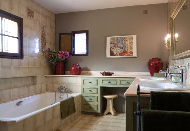 Badezimmer mit Doppelwaschbecken, Badewanne und Dusche in der Villa 83REN