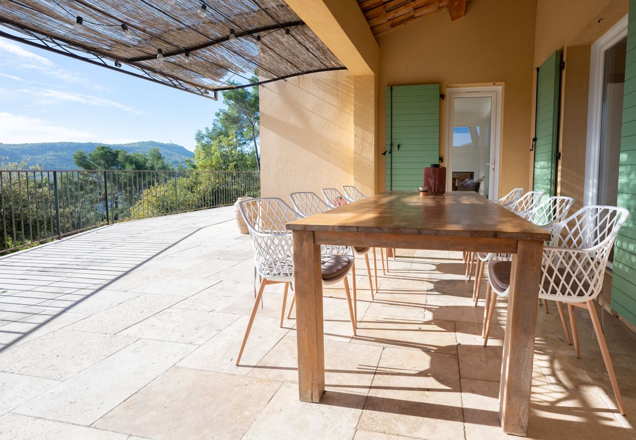 Abendessen auf der überdachten Terrasse der Villa Tourrettes mit Holzesstisch, Designerstühlen, malerischer Aussicht