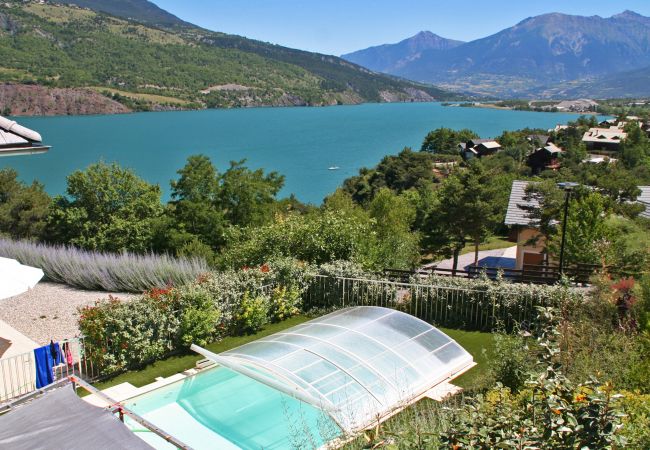 Swimming pool with retractable cover and mountain backdrop at Villa Dalaromer