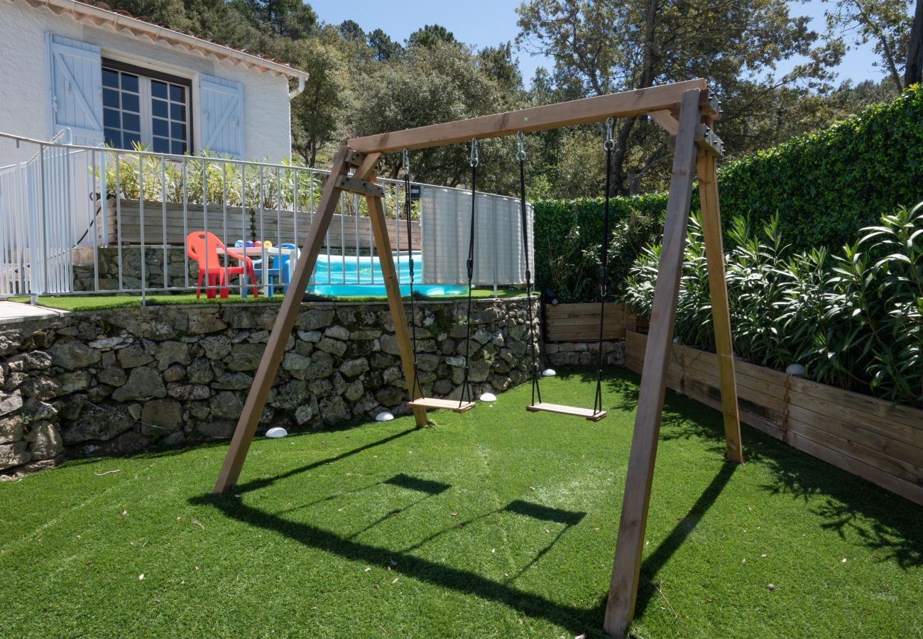 Captivating image of Villa Bellevue's fenced children's area, featuring swings, a playhouse,
