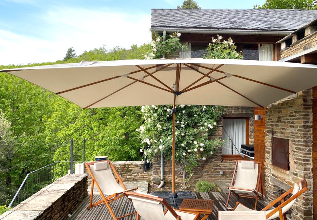 Savor the terrace dining at La Bastide 48BAST, adorned with a large dining table, parasol, and a stunning panoramic view.