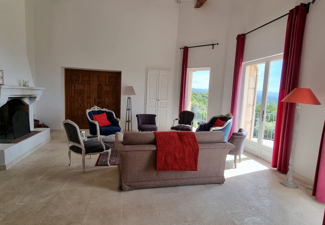 Salon confortable avec portes-fenêtres, cheminée et vue imprenable - Villa Chris, Murs, Lubéron, Provence