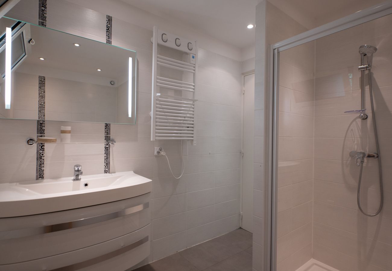 Salle de bains moderne de la Villa 06PETE avec une douche à l'italienne, créant une oasis élégante et rafraîchissante.