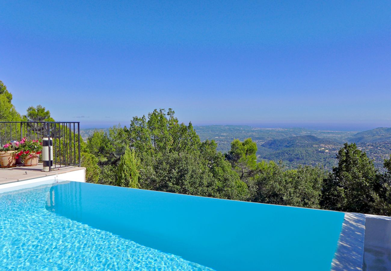 Vue envoûtante de la piscine à débordement et du paysage panoramique à la Villa Lou Bea, offrant sérénité et détente