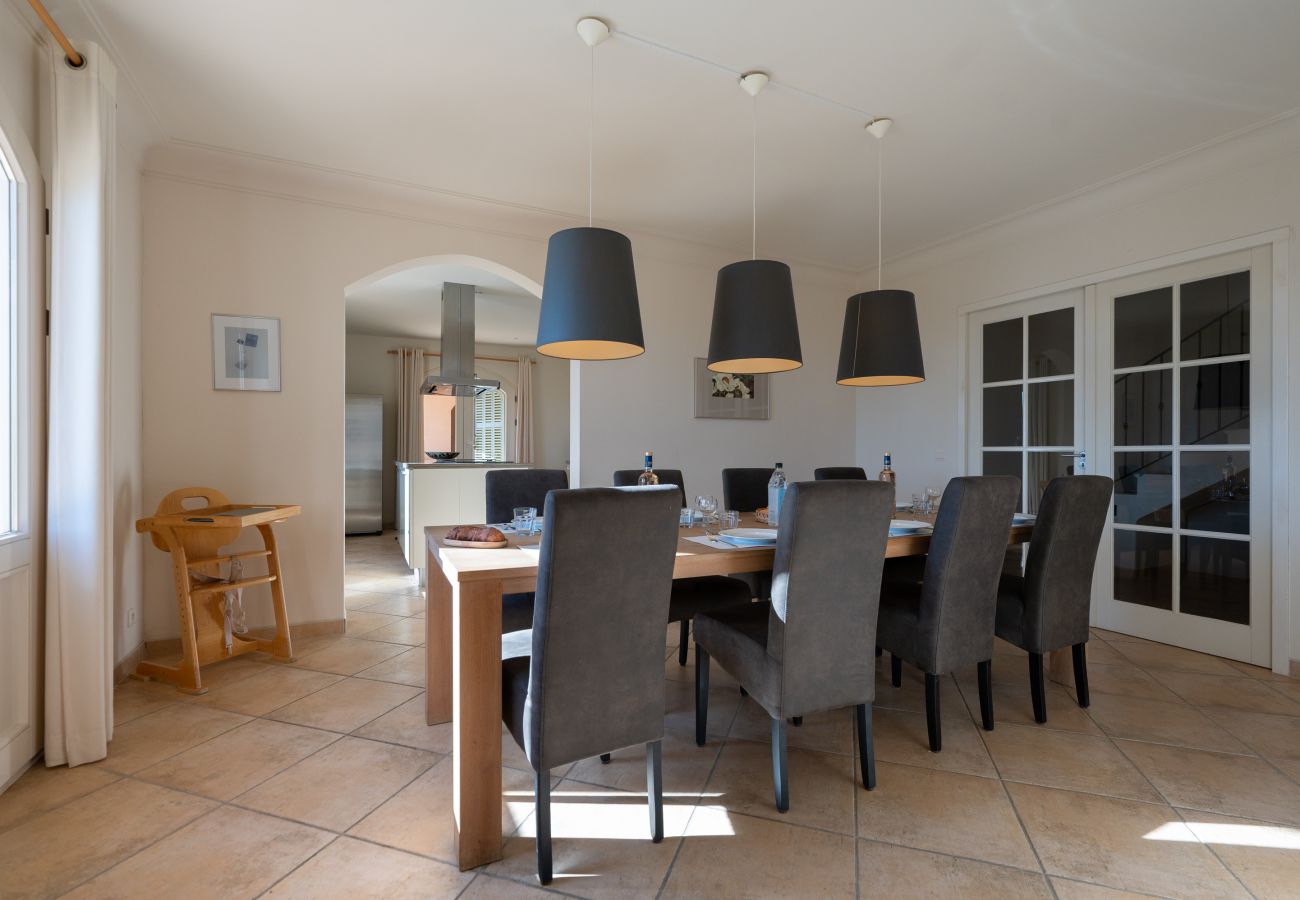 L'espace repas de la Villa 06PRAD avec une table élégante, des chaises confortables, un accès à la cuisine et au salon
