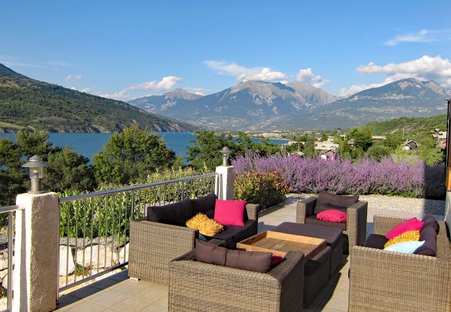 Villa 05DAME - Photo de la terrasse avec coin salon et vue sur le lac et les montagnes