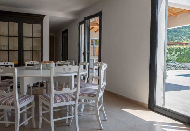Profitez de vos repas avec cette table à manger confortable près des portes-fenêtres - Villa Beaumont, Malaucène, Provence.