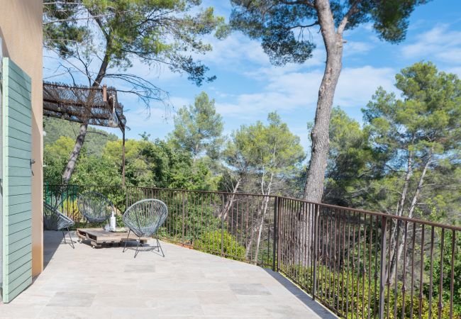 Sérénité sur la terrasse allongée de la Villa Tourrettes, avec l'impression de planer parmi les cimes des arbres.