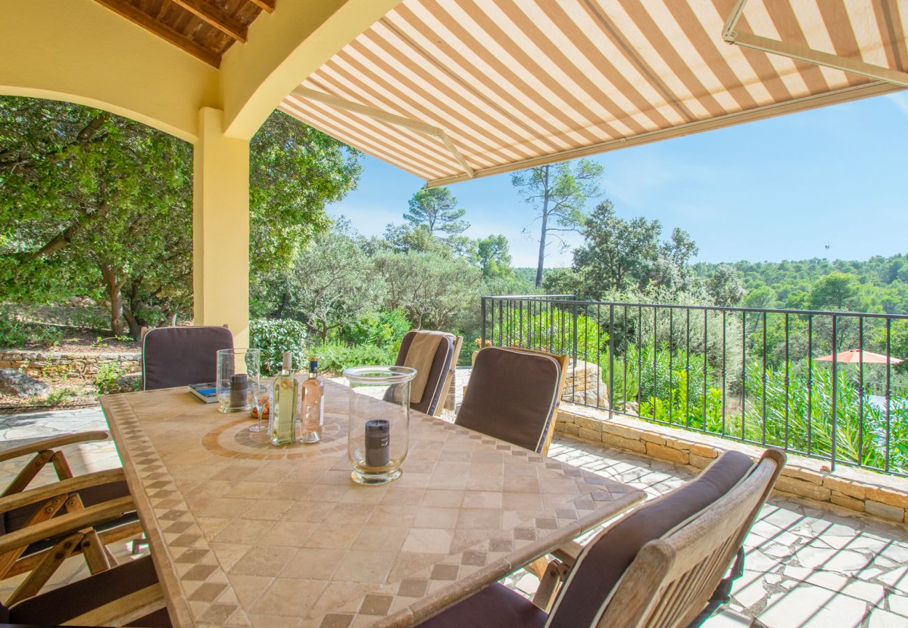 Overdekt terras bij Villa Sygu met een eettafel en panoramisch uitzicht over het Provençaalse landschap