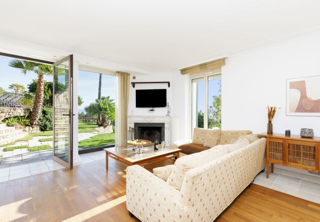 Villa 06LERI: Luxe woonkamer met een sofa, flatscreen en uitzicht op de tuin - Théoule-sur Mer, Côte d'Azur