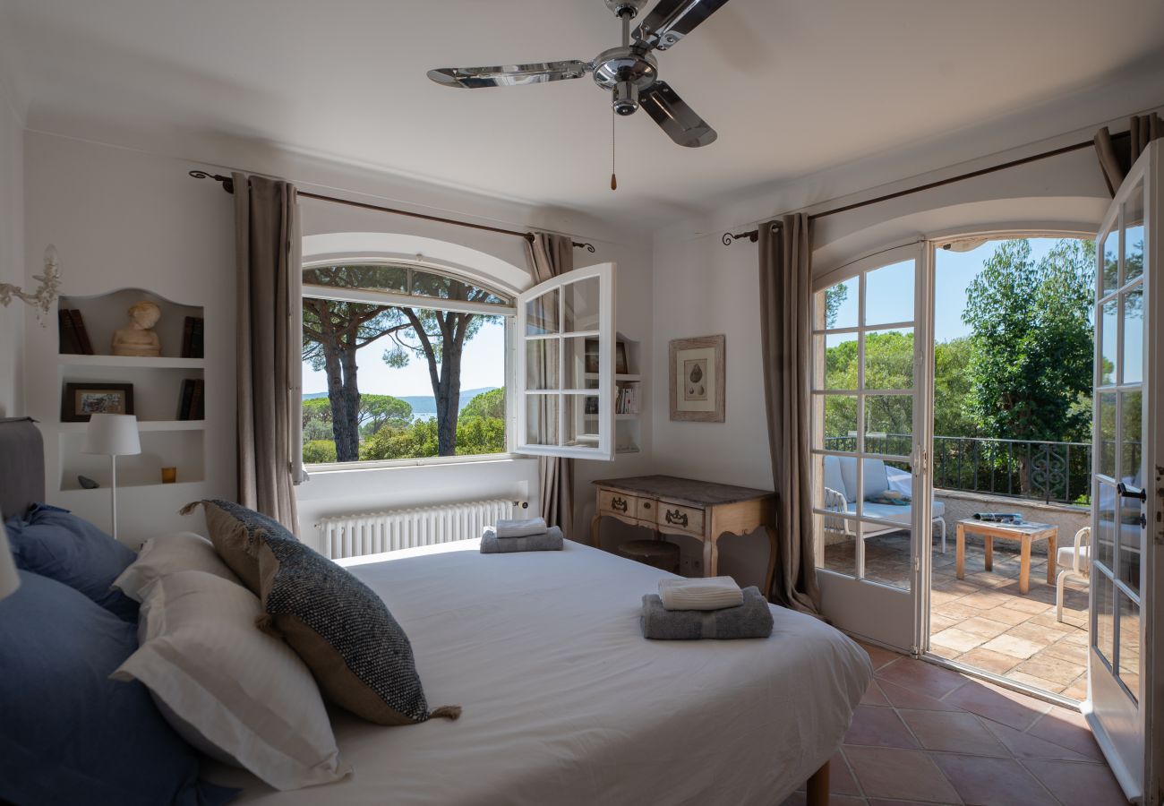 Slaapkamer met zeezicht en terrastoegang bij Villa Toscane