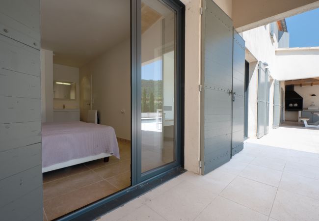 Comfortabel tweepersoonsbed met ensuite badkamer en schuifpuien naar het terras in Villa Beaumont, Malaucène, Provence.